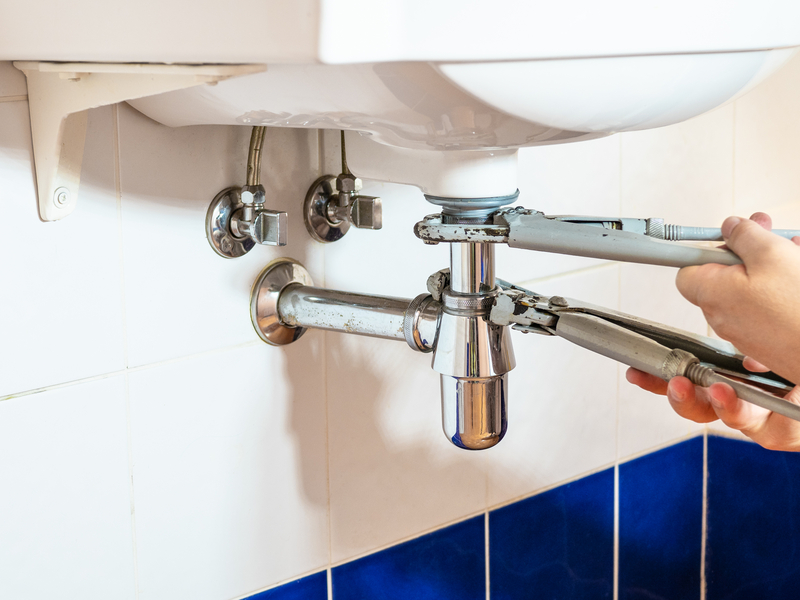 broken sink pipe being fixed